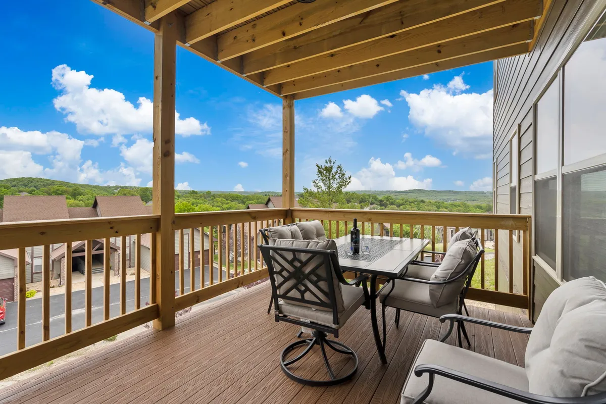 This image captures an outdoor dining set beneath a wooden ceiling structure, overlooking a scenic natural view. The setting evokes a sense of tranquility and relaxation, inviting guests to enjoy morning coffee, al fresco meals, or quiet moments while taking in the surroundings.
